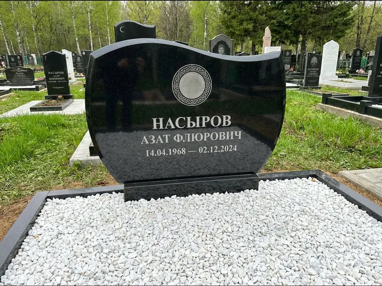 Мусульманский памятник: стела с волнообразным скошенным верхом — гравировка мечети под полумесяцем и звёздами, белая мраморная крошка с бордюром, работа «Насыров» в Москве