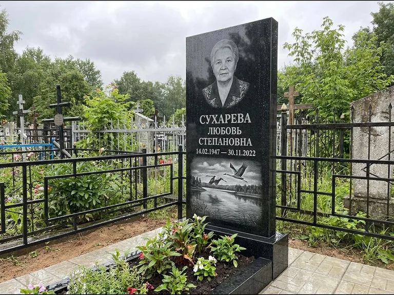 Памятник с гравировкой журавлей — гравировка пары журавлей над гладью озера в нижней части, работа «Сухарева» в Москве