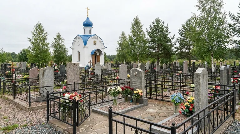 Мастер мастерской «Мастер Каменев» устанавливает гранитный памятник на участке Иликовского кладбища